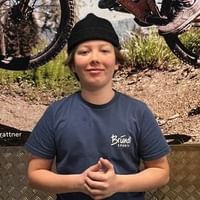 Anton stands in front of a picture with a mountainbiker