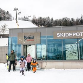 A family leaves the Bründl Sports ski depot in Zell am See and goes skiing
