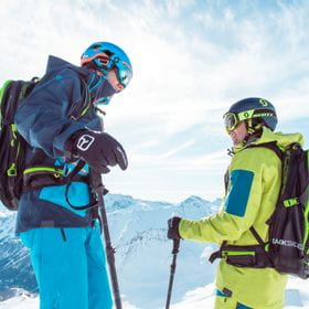 zwei Skifahrer reden miteinander während einer Freeride-Tour