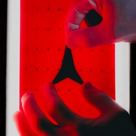Close-up of a hand applying the Atomic logo to a Redster ski.