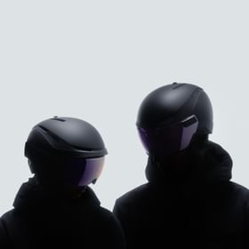 Two skiers wearing Atomic Revent helmets with visors. 