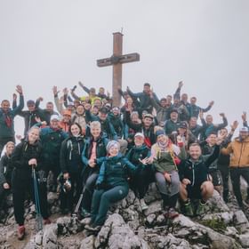 The managers cheering in front of a summit cross.