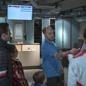 a man explains the check-in station to rent skiing equipment