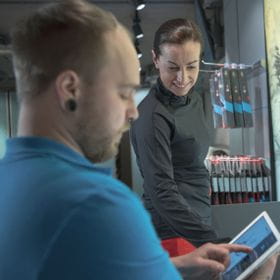 an employee shows information on a tablet to a customer