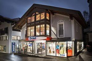 Beleuchtetes Schaufenster des Bründl Sports Saalbach Zentrum Shops - Abendaufnahme <br/>