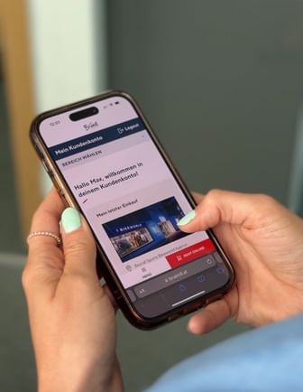 Auf dem Bild sieht man eine Bründl Sports Mitarbeiterin die sich für das Kundenkonto auf ihrem Handy registrieren will.