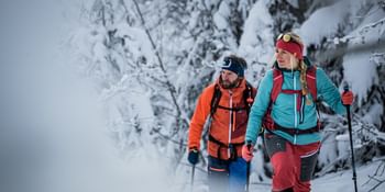 two people on a ski tour through winter wonderland dressed in Ortovox