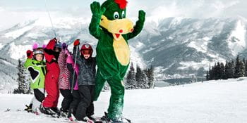 das Bild zeigt einer Kindergruppe beim Skifahren lernen