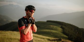 Portrait of a cyclist as he opens his helmet.