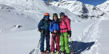 Drei Skifahrer in den verschneiten Alpen