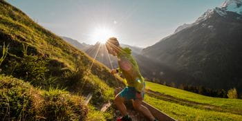 a person runs in the mountains when the sun is rising