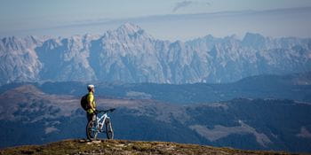 ein Radfahrer vor einer Gebirgskette in Zell am See