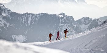 a group of people doing a skitour dressed in salewa products 