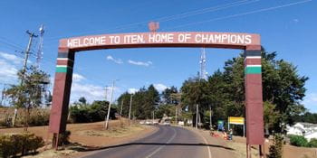 an archway over the road with the slogan “Welcome to Iten. Home of Champions” 