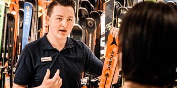 Bründl Sports employee explains everything about an Atomic ski to a consumer