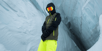 Skifahrer steht vor einer großen Gletscher- bzw. Eishöhle<br/>