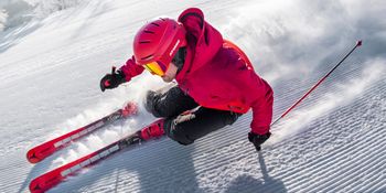 A skier carving down a slope with the new Atomic Redster Revoshock