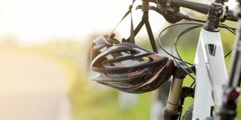 a helmet is hanging from the handlebar of a bycicle