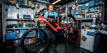 A staff member with a bike in the bicycle repair shop
