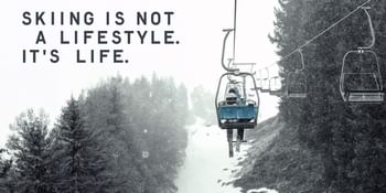 A skier sits alone on a chairlift in falling snow, surrounded by snowy trees – featuring the slogan “Skiing is not a lifestyle. It’s life.” and the Fischer logo.
