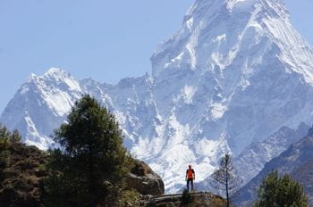 a runner stands in front of a snow-covered mountain