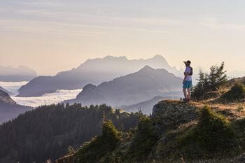 a trailrunner enjoys the view on the alpine mountain tops