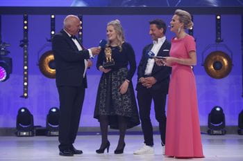 Valentina Höll and Christoph Bründl on stage, standing between the two hosts of the Leonidas Fritz Egger and Alexandra Meissnitzer 
