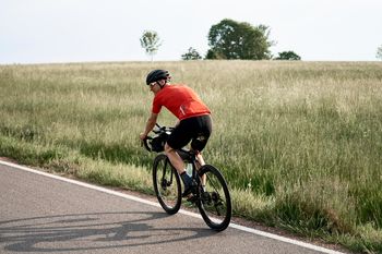 Biker on the road infron af a field