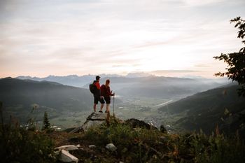 Hikers on a viewpoint with a sunset in the background