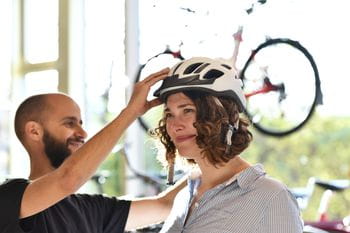 a woman tries to fit a bycicle helmet
