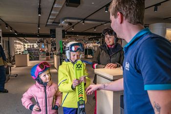 A family renting some ski by Bründl Sports. 
