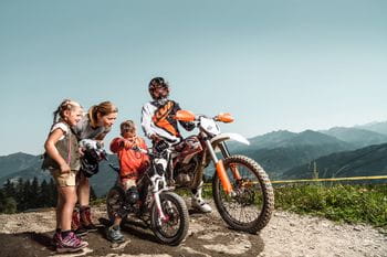 ein Motocrossfahrer und zwei Kinder