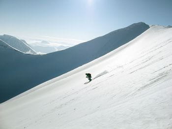 Freerider skiing down an untracked powder slope