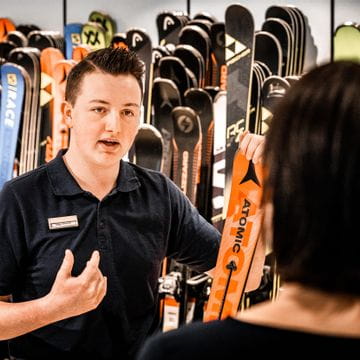 Verkäufer bei Bründl Sports erklärt einer Kundin einen Atomic Ski