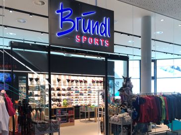 Auf dem Bild ist der Eingang zum Bründl Sports Shop in Fügen zu sehen.