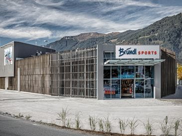 Bründl Sports Saalfelden von außen mit großem Parkplatz <br/>