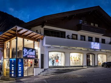 Bründl Sports Shop im Zentrum von Mayrhofen von außen bei Dämmerung. 