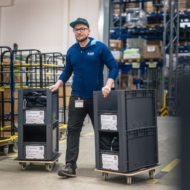 Bründl Sports Mitarbeiter Tom befördert Ware in der Logistik