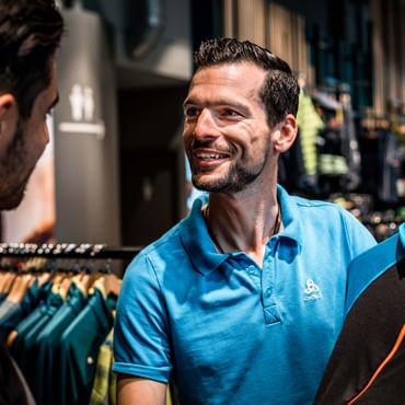 an employee presents a pullover to the customer