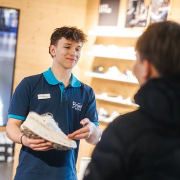 Lehrling beim Verkauf von Schuhen