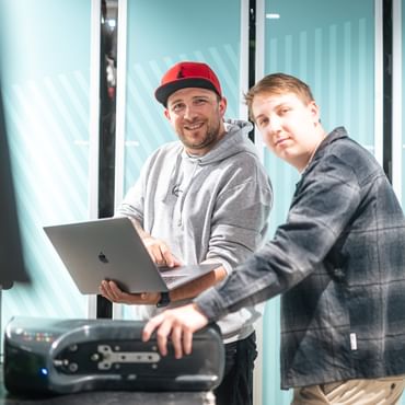 Zwei IT-Servicetechniker während ihrer Arbeit im Bründl Sports Shop