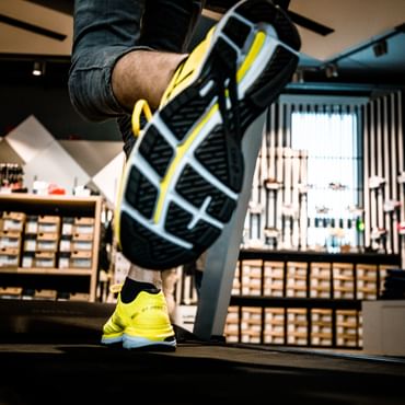A detailed look on the tread of running shoes while someone is running on a treadmill