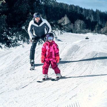 Father and girl skiing in Kaprun
