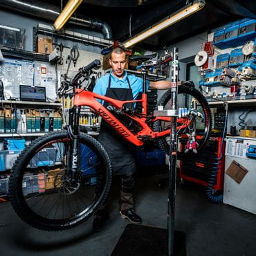 A staff member with a bike in the bicycle repair shop