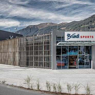 Bründl Sports Saalfelden von außen mit großem Parkplatz <br/>