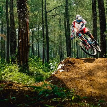Downhiller jumps over a tramp in the forest