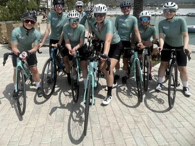 WattWomen team photo dressed in the same uniforms holding their bikes