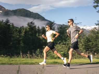 Two Runner on a path with mountains in the background