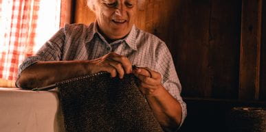 Eine ältere Dame beim Stricken mit Wolle 