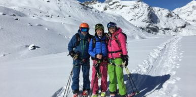 Three skiers at the snowy Alps